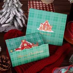 Detailed view of green plaid Christmas cards with gold foil lettering and festive props