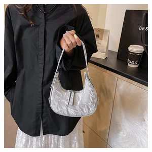 Close-up of silver wrinkled metallic crescent bag with double zipper and stylish texture
