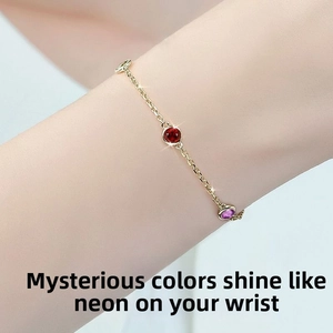 Detailed close-up of a delicate gold chain bracelet featuring vibrant round-cut gemstones