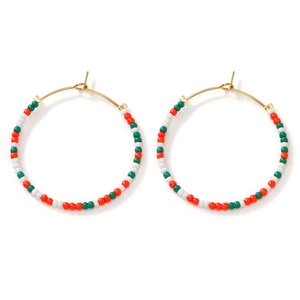 Detail of bohemian hoop earrings with red, white and green seed beads on gold wire