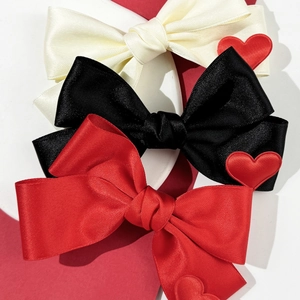 Drei Satin-Haarschleifen in Beige, Schwarz und Rot mit roten 3D-Herz-Anhängern