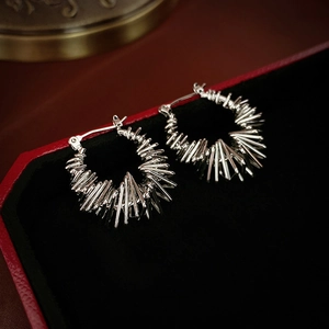 Silver hoop earrings with spike fringe design on black velvet jewelry case display