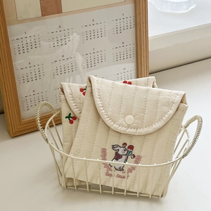 Detail of quilted cotton sanitary pouch with cute rabbit embroidery in a white basket