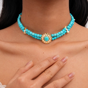 Close-up of double-layer beaded necklace with turquoise stone and floral pendant
