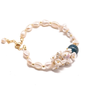 Baroque freshwater pearl bracelet with blue kyanite and gold beads on white background