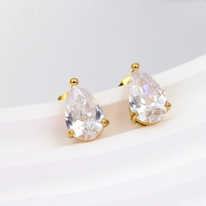 Macro view of gold pear-cut cubic zirconia stud earrings with three-prong setting