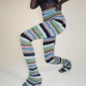 Détail d'un pantalon en maille à rayures colorées avec une coupe ajustée et taille haute