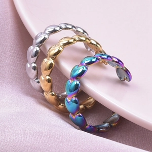 Detailed macro view of heart chain rings in silver, gold, and rainbow metallic finishes