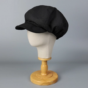 Casquette gavroche noire classique pour femme avec structure à huit pans sur un support de tête