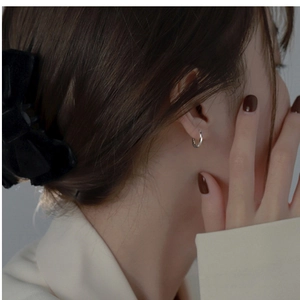 Close-up of minimalist S925 sterling silver hoop earring worn on a model's ear