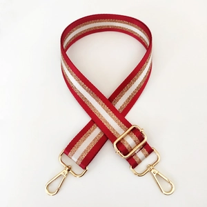 Close-up of adjustable nylon bag strap with red, white, and gold striped pattern