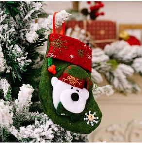 Detail of felt Christmas stocking with polar bear and snowflake on snowy tree