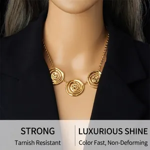 Detailed view of large golden rose pendant necklace on model with black suit