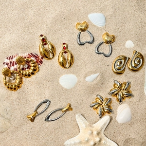 Vue à plat de boucles d'oreilles marines avec coquillages et étoiles de mer sur le sable