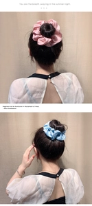 Detailed view of oversized glossy pleated satin hair scrunchies in pink and blue colors