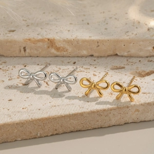 Elegant gold and silver bow stud earrings in 18K plated stainless steel on stone