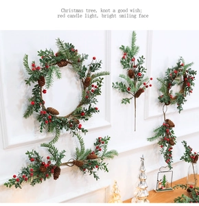 Close-up of Christmas wreath and swag with pine needles, red berries, and pinecones