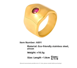 Macro detail of gold stainless steel ring featuring a centered red oval zircon stone