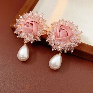 Detail of pink fabric rose earrings with white teardrop pearls and crystal beads