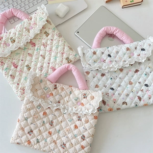 Detail of quilted laptop sleeves with floral cartoon prints and elegant lace borders
