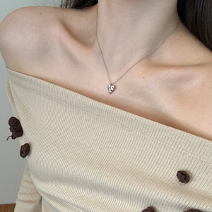 Detail showing the S925 sterling silver brushed heart necklace worn on a model's neck