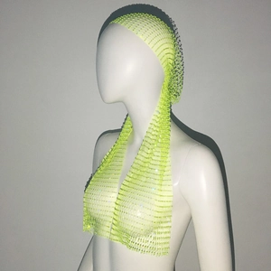 Close-up of neon green rhinestone mesh headpiece and vest with sparkling crystal grid