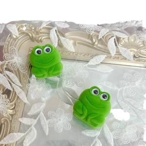 Flocked green frog-shaped jewelry gift boxes displayed on a vintage gold mirror