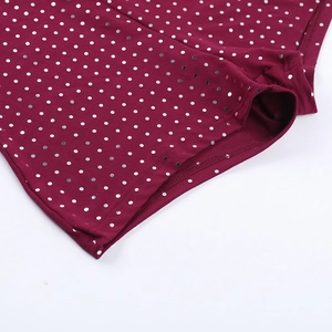 Gros plan détaillé du tissu tricoté bordeaux avec paillettes argentées et coutures