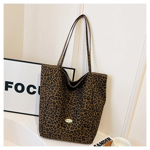 Detail of leopard print tote bag featuring the handmade metal nameplate and canvas texture