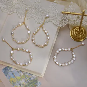 Close-up of baroque irregular pearls with 14K gold-filled clasp on vintage lace backdrop