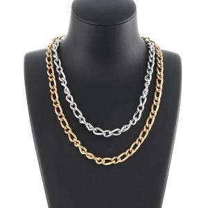 Two-tone gold and silver stainless steel curb chain necklaces on a black display bust