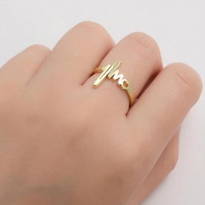 Detail of polished gold heartbeat ring with EKG wave and heart pattern on finger
