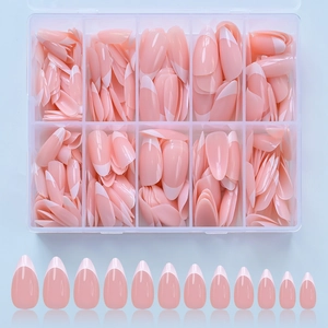 Detailed view of nude pink French almond press-on nails organized in a clear storage box