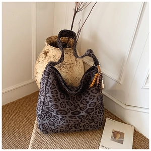 Detail showing vintage leopard print tote with wooden bead tassel and wide shoulder strap