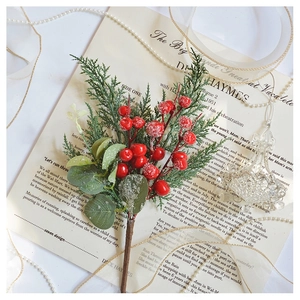 Close-up of frosted red berries and pine needles on vintage paper with pearls
