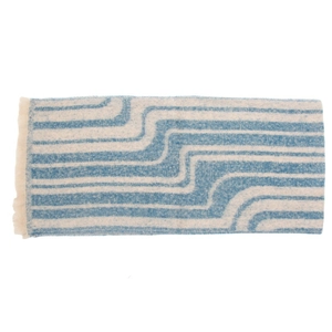 Detailed view of woven blue and white wavy geometric patterns on scarf with soft fringes
