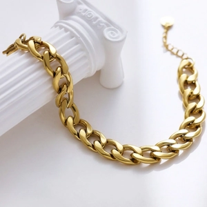 Gold chunky chain bracelet in minimalist titanium steel on a white classical column