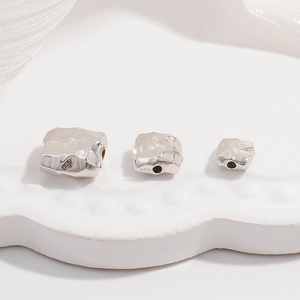 Macro shot of three S925 sterling silver square spacer beads with hammered texture