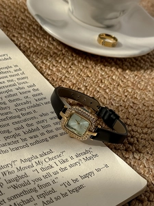 Détail d'une montre carrée vintage avec lunette sertie de diamants et bracelet en cuir
