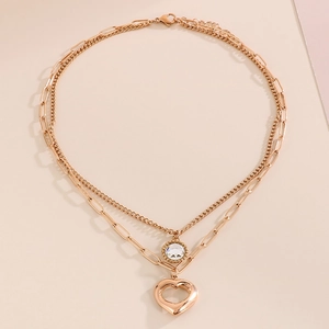 Dettaglio della collana a doppio strato oro rosa con ciondolo a cuore e catena a graffetta