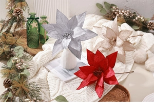Détail de fleurs de poinsettia artificielles scintillantes en champagne, rouge et argent