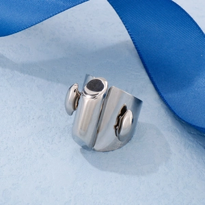 Close-up of wide polished silver stainless steel ring on blue silk texture background