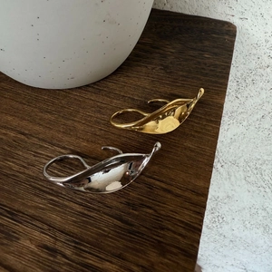 Golden and silver exaggerated leaf-shaped open rings with a polished metallic finish