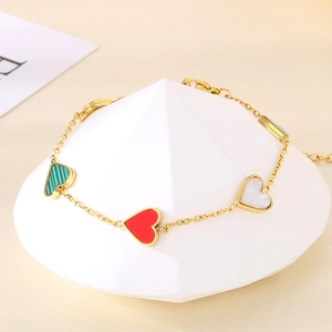 Golden titanium steel chain bracelet with colorful heart shell pendants on white pedestal