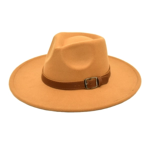 Détail du chapeau en laine camel avec un ruban en cuir marron et une boucle métallique