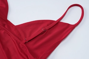 Detail of adjustable metal buckle on thin red strap with smooth elastic fabric texture