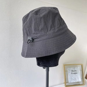 Close-up of charcoal grey nylon bucket hat featuring adjustable elastic drawcord toggle