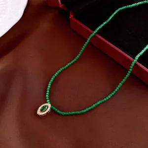 Vintage green beaded necklace with gold-rimmed marquise gemstone pendant and zircon stones