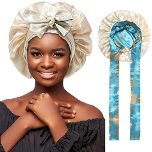 Detail of beige satin sleep cap featuring blue patterned lining and adjustable long ribbons