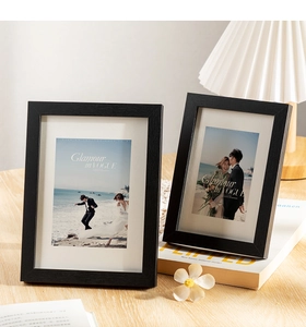 Detail of black wood grain frame with white mat and artistic photo in cozy home setting